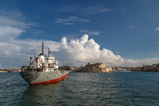 VALETTA, MALTA - NOVEMBER 2, 2015 : View of Valletta with ships and boats on coastline, on cloudy sky background.