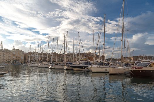 VALLETTA, MALTA - NPVEMBER 2, 2015 : View of Valletta marina with sailing boats, yatches and ships around, on cloudy sky background.