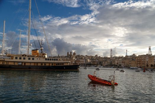 VALLETTA, MALTA - NPVEMBER 2, 2015 : View of Valletta marina with sailing boats, yatches and ships around, on cloudy sky background.