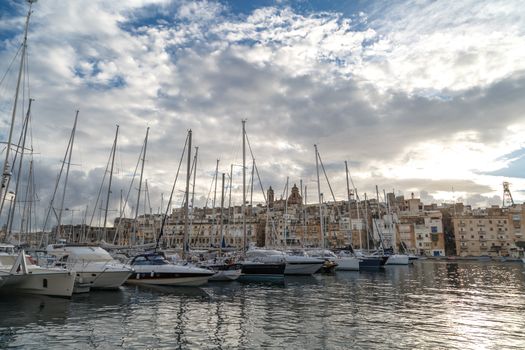 VALLETTA, MALTA - NPVEMBER 2, 2015 : View of Valletta marina with sailing boats, yatches and ships around, on cloudy sky background.