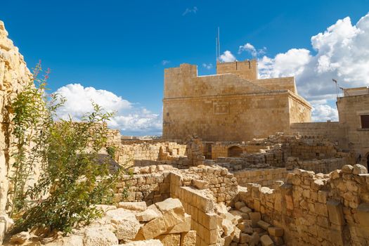 View of Cittadella, historical fortified small city of Cittadella with limestone structures, on cloudy blue sky background.