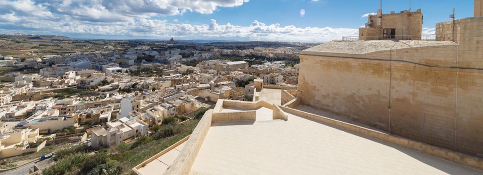 View of Cittadella, historical fortified small city of Cittadella with limestone structures, on cloudy blue sky background.