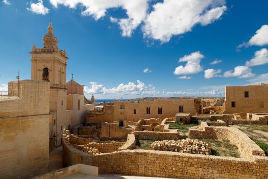 View of Cittadella, historical fortified small city of Cittadella with limestone structures, on cloudy blue sky background.