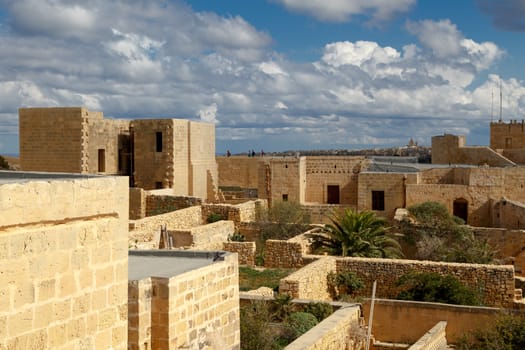 VICTORIA, MALTA - OCTOBER 31, 2015 : View of Cittadella, historical fortified small city of Cittadella with limestone structures, on cloudy blue sky background.