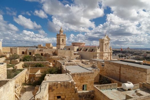 View of Cittadella, historical fortified small city of Cittadella with limestone structures, on cloudy blue sky background.