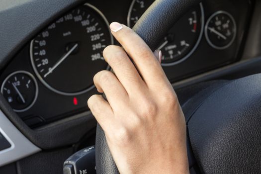 the girl with the manicure keeps hands on the steering wheel of the car