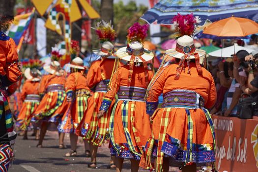 Tinku dancing group in colourful costumes performing a traditional ritual dance as part of the Carnaval Andino con la Fuerza del Sol in Arica, Chile.
