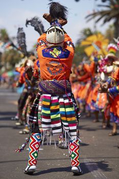 Tinku dancing group in colourful costumes performing a traditional ritual dance as part of the Carnaval Andino con la Fuerza del Sol in Arica, Chile.