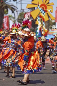 Tinku dancing group in colourful costumes performing a traditional ritual dance as part of the Carnaval Andino con la Fuerza del Sol in Arica, Chile.