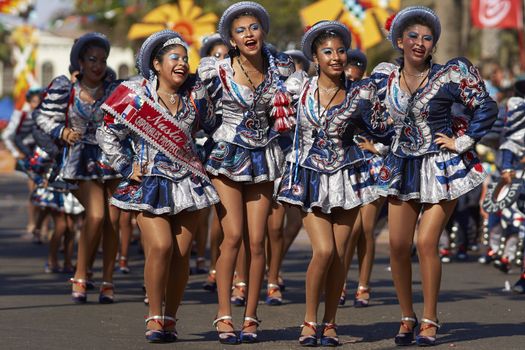 Female members of a Caporales dance group in ornate costumes performing at the annual Carnaval Andino con la Fuerza del Sol in Arica, Chile.