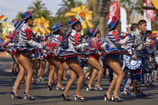 Female members of a Caporales dance group in ornate costumes performing at the annual Carnaval Andino con la Fuerza del Sol in Arica, Chile.