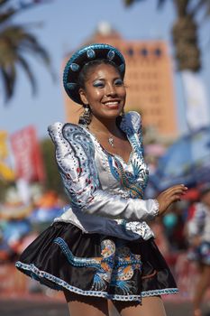 Female members of a Caporales dance group in ornate costumes performing at the annual Carnaval Andino con la Fuerza del Sol in Arica, Chile.