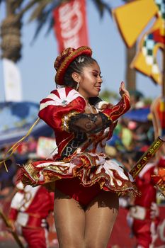 Caporales dancer in ornate costumes performing at the annual Carnaval Andino con la Fuerza del Sol in Arica, Chile.