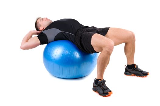 Young man shows starting position of Abdominal Fitball Workout, isolated on white