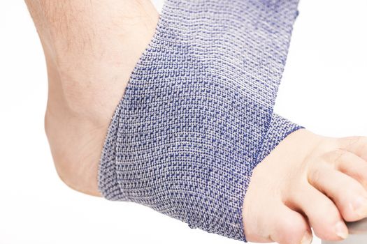 Man doing a bandage on foot ankle white background France