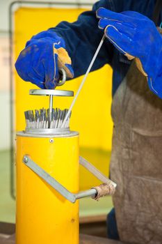 Hands of a man taking a welding stick