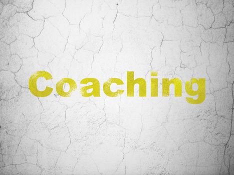 Learning concept: Yellow Coaching on textured concrete wall background