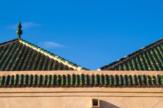 Colorful moroccan Marrakesh, the colors highlited by the time of golden hour, with a blue sky and some clouds.