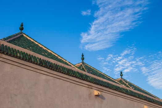 Colorful moroccan Marrakesh, the colors highlited by the time of golden hour, with a blue sky and some clouds.