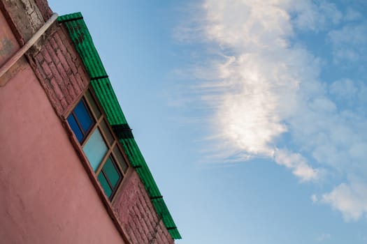 Colorful moroccan Marrakesh, the colors highlited by the time of golden hour, with a blue sky and some clouds.