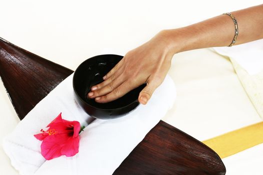 Hands of the masseur with a cup with aloe