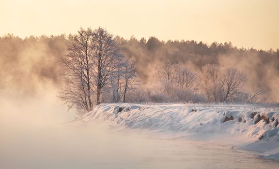 Winter dawn. Winter foggy sunrise on the river. Winter morning mist.