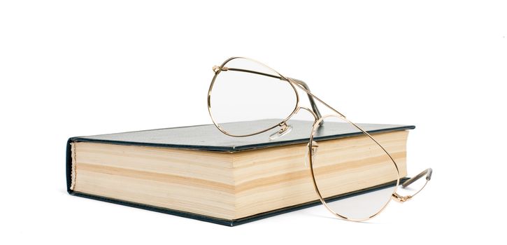 Book with glasses isolated on white background