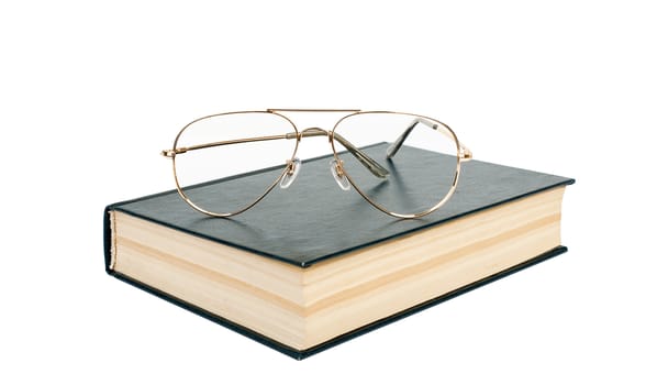 Closed book with glasses isolated on white background, close up view