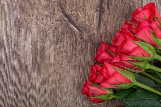 Red roses on a brown wooden background