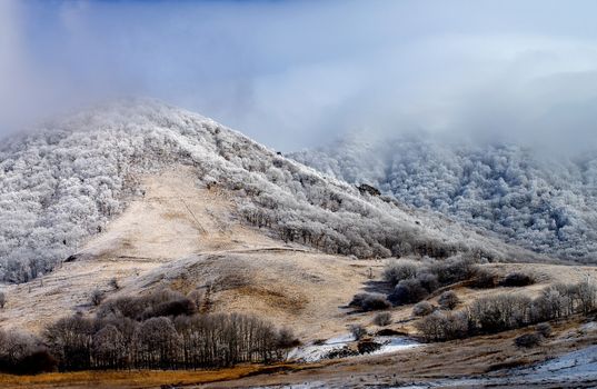 Snowy Mount Beshtau Ridges and Hills with Frozen Trees on Cloudy Sky background Outdoors