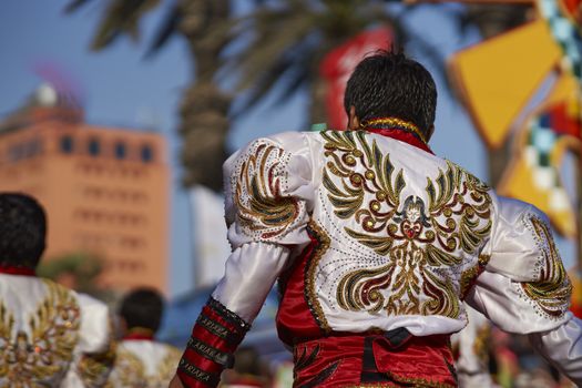 Male Caporales dancer in ornate costume performing at the annual Carnaval Andino con la Fuerza del Sol in Arica, Chile.