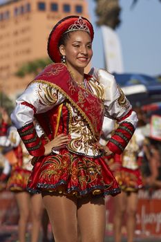 Caporales dancers in ornate costumes performing at the annual Carnaval Andino con la Fuerza del Sol in Arica, Chile.