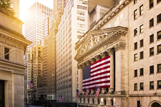 Famous Wall street and the building in New York, New York Stock Exchange with patriot flag