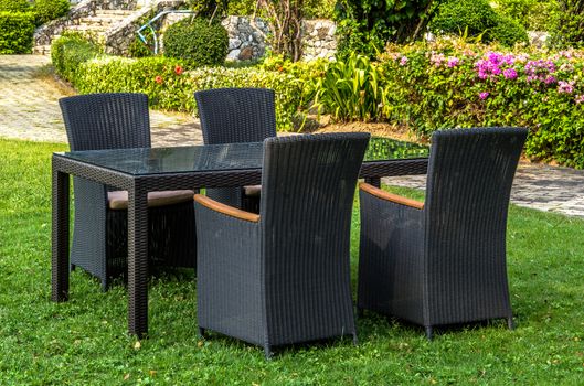 Rattan furniture, table, chairs and cushion outdoors in the garden