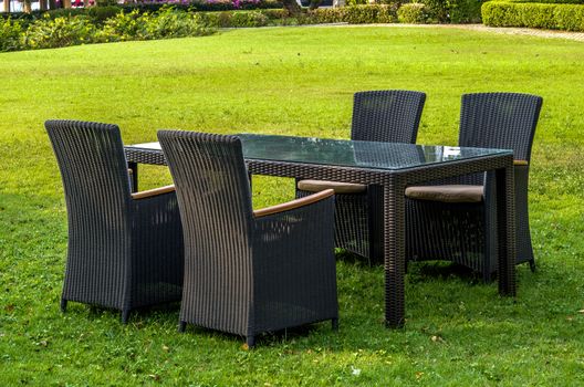 Rattan furniture, table, chairs and cushion outdoors in the garden