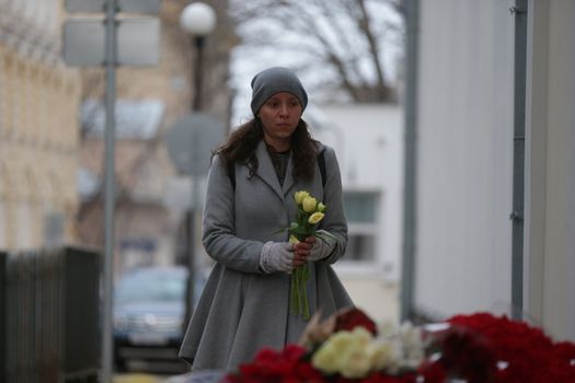 RUSSIA, Moscow: A woman adds to the makeshift memorial outside the Belgian Embassy in Moscow, Russia, following the terror attacks that left at least 30 dead and hundreds injured in Brussels, Belgium on March 22, 2016. The Islamic State terror group has taken responsibility for the attacks, which brought death and destruction on Zaventem airport and Maelbeek metro station.