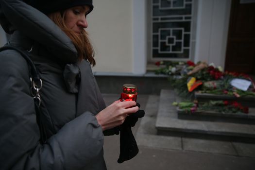 RUSSIA, Moscow: A woman holds a candle at a makeshift memorial outside the Belgian Embassy in Moscow, Russia, following the terror attacks that left at least 30 dead and hundreds injured in Brussels, Belgium on March 22, 2016. The Islamic State terror group has taken responsibility for the attacks, which brought death and destruction on Zaventem airport and Maelbeek metro station.