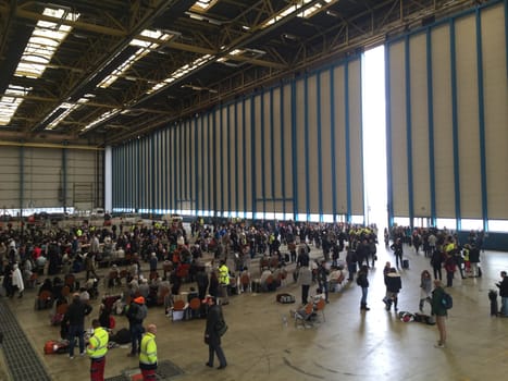 BELGIUM, Brussels: Passengers sit stranded in a hangar at Zaventem airport on March 22, 2016, after terrorist bombings killed at least 30 people, both at the airport and at Maelbeek metro station.Pictures show hundreds of passengers stranded after the attack.