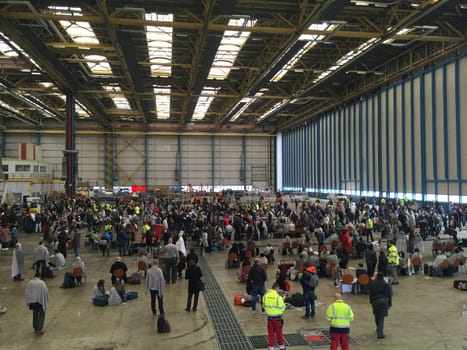 BELGIUM, Brussels: Passengers sit stranded in a hangar at Zaventem airport on March 22, 2016, after terrorist bombings killed at least 30 people, both at the airport and at Maelbeek metro station.Pictures show hundreds of passengers stranded after the attack.