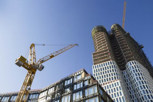 Construction site in city with yellow crane.