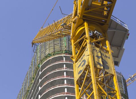 Construction site in city with yellow crane.