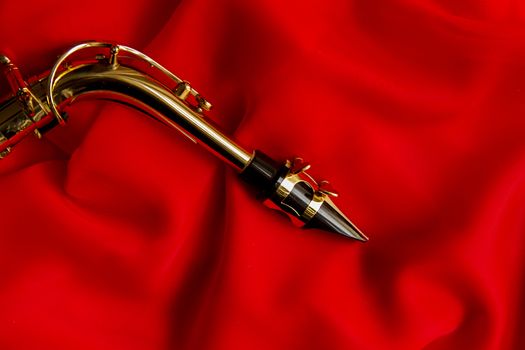beautiful golden saxophone on delicate red silk background