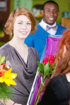 Smiling teenager purchasing roses at a florist shop