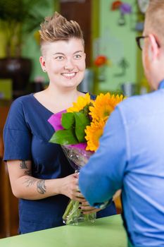 Woman buying sunflowers at a florist shop