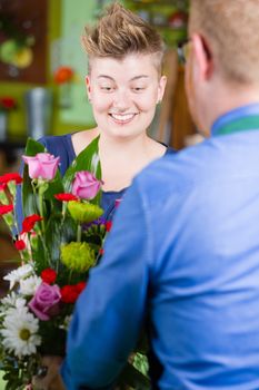 Pretty woman buying arrangement at a florist shop