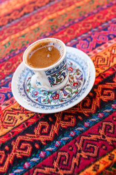 Turkish style coffe in traditional small cup on colorful background