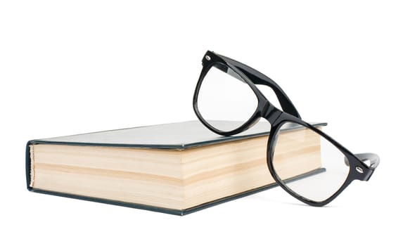 Book with eyeglasses isolated on white background, close up view
