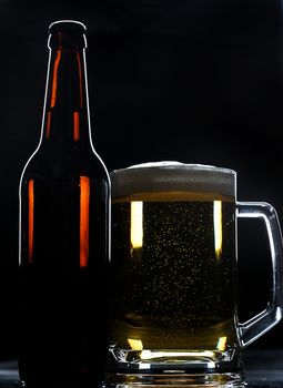 beer bottle and glass on black background