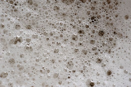 macro of bubbles on beer foam in glass