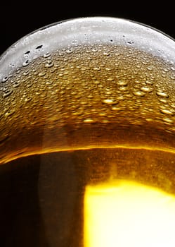 close up of bubbles on beer foam in glass